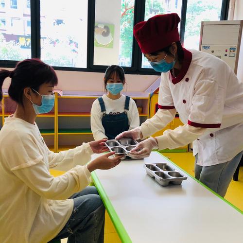 保育员将已经消毒好的餐具派发给幼儿,幼儿与幼儿隔开距离进行